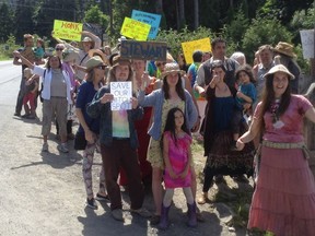 Salt Spring Island residents protest outside the Embe Bakery on Monday after the local RCMP detachment started cracking down on hitchhiking.