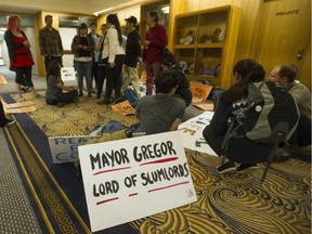 Residents of the Balmoral Hotel in Vancouver, B.C. and social housing activists stage a sit-in outside mayor Gregor Robertson's office at Vancouver city hall Thursday, June 1, 2017.