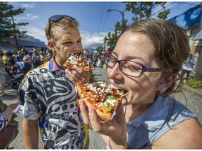 Stefan Gronsdahl and Mehan Seiling eat pizza while enjoying Italian Day on Commercial Drive in Vancouver on Sunday.  Commercial Drive was transformed into a festive, 14-block celebration zone, filled with over 200 exciting merchants, food vendors, live entertainment and more.