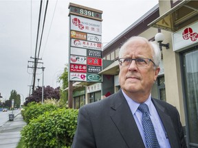 Mayor Malcolm Brodie in front of signs in Richmond on Thursday. City council is considering implementing a controversial language bylaw as a way to address concerns around Chinese-only signage.