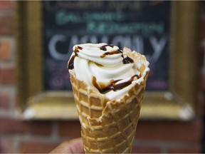 A vanilla ice cream cone with chocolate drizzle.