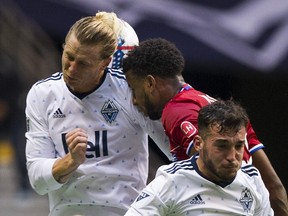 FC Dallas's Kellyn Acosta is caught between Vancouver Whitecaps Brek Shea, left, and Russell Teibert during Saturday night's game at B.C. Place. The game ended in a 1-1 tie.