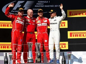 Second placed Ferrari driver Kimi Raikkonen of Finland, left, winner Ferrari driver Sebastian Vettel of Germany, 2nd right, and third placed Mercedes driver Valtteri Bottas of Finland, right, pose on the podium of the Hungarian Formula One Grand Prix, at the Hungaroring racetrack in Mogyorod, northeast of Budapest, Sunday, July 30, 2017. (AP Photo/Darko Bandic)