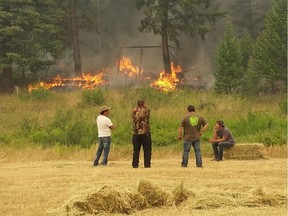 Many members of the Xatsull First Nation, north of Williams Lake, stayed behind to fight fires and protect the community by themselves. Here several men keep an eye on a fire, just hours before wind picked up and the chief and council issued an evacuation order, after deciding it was too dangerous to stay and fight.