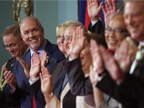 Premier John Horgan smiles at cabinet members after being sworn-in as Premier during a ceremony with his provincial cabinet at Government House in Victoria, B.C., on Tuesday, July 18, 2017.