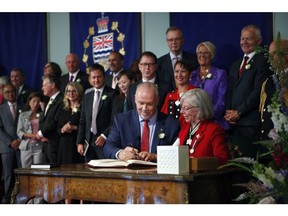 Premier John Horgan takes an oath with Lieutenant-Governor Judith Guichon as he's sworn-in as Premier during a ceremony with his provincial cabinet at Government House in Victoria, B.C., on Tuesday, July 18, 2017.