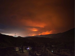 A wildfire burns on a mountain east of Cache Creek behind a trailer park that was almost completely destroyed by the blaze in Boston Flats on July 10.