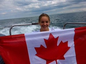 Emily Epp is seen in an undated handout photo holding a Canadian flag on board a boat on the English Channel. The 17-year-old from Kelowna just swam the English Channel and raised more than $40,000 for the children's hospice Canuck Place.