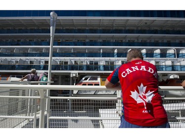 A man checks out a cruise ship berthed Canada Place during the Canada Day celebrations, Vancouver, July 01 2017.