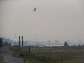 A helicopter carrying a bucket picks up water while battling the Gustafsen wildfire near 100 Mile House on the weekend.