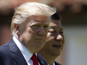 In this April 7 file photo, U.S. President Donald Trump, left, and Chinese President Xi Jinping walk together at Mar-a-Lago in Palm Beach, Fla.