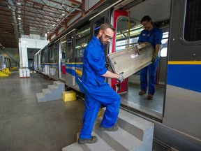 B.C. Rapid Transit Company vehicle project technicians Loris Michelin (right) and Jimmy Whitelock dismantle Skytrain cars at the company's OMC2 maintenance facility in Burnaby. One hundred and fourteen Expo-era train cars, representing 40 per-cent of the Skytrain fleet, are in the midst of being refurbished.