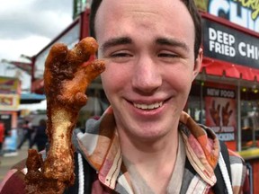 Reporter Dustin Cook tries deep-fried chicken feet at Chicky's Chicken at K-Days in Edmonton, July 21, 2017.