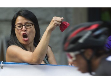 Riders in the women's  Global Relay Gastown Grand Prix are cheered on by a spectator , Vancouver, July 12 2017.