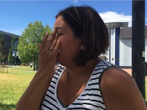 Krista Billy wipes away tears as she talks about the prospect of losing her home in Hat Creek. Her family of five was evacuated and waited outside the Kamloops Emergency Social Services reception centre on Sunday.