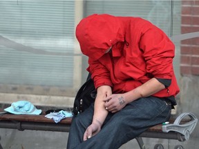 A man injects himself at a bus shelter in Vancouver's Downtown Eastside, Monday, Dec.19, 2016. The number of overdose deaths related to illicit drugs in British Columbia leapt to 755 by the end of November, a more than 70-per-cent jump over the number of fatalities recorded during the same time period last year.