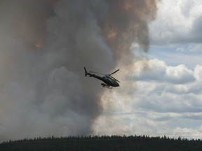 A helicopter flies near a wildfire on Tsilhqot'n Nation land near Williams Lake on Thursday.