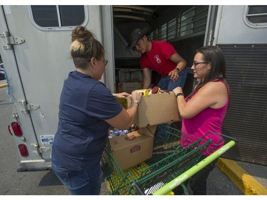 Daana Gilpin (left) and Linda Haig-Brown hand Johnny Lulua supplies destined for the Xeni Gwet'in band of the Tsilhqot'in First Nation, at the Save On More grocery store in Williams Lake Friday, July 14, 2017. Hundreds of the nation's members have decided not to evacuate their homes due to wildfires so supplies must be brought to them.