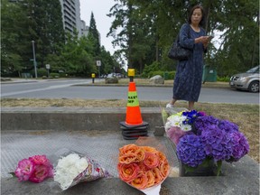 Family friend Emma Liu looks at flowers and teddy bears that mark a memorial to Marrisa Shen on the east side of Central Park in Burnaby on Friday. Shen was found dead in the park early Wednesday morning. Police continue their investigation.