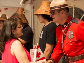 Gloria Cardenas is congratulated on becoming a Canadian by RCMP Sgt. Chad Greig after a ceremony at Fort Langley on July 1, 2017.