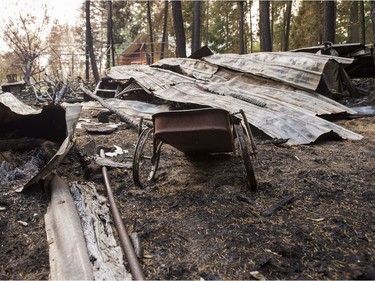 The charred remains of a wagon sits next to a burnt out building on a property after the Soda Creek Fire jumped across the Fraser River near Alexandria, BC, July, 16, 2017.