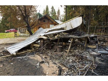 The charred remains of an out building is seen sitting in front a home saved by firefighters after the Soda Creek Fire jumped across the Fraser River near Alexandria, BC, July, 16, 2017.