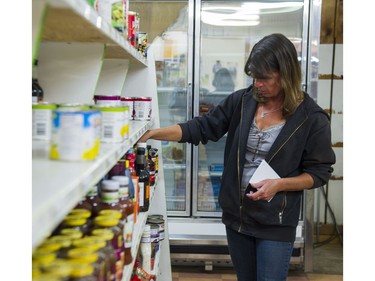 Lisa McInnes takes stock of what is left on the shelves at Clarkes General Store in Horsefly, BC, July, 17, 2017. Road closures due to the forest fires burning in the area has made it difficult for supplies to be brought into the community and to the store.