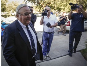 Winston Blackmore of Bountiful, found guilty this week of practising polygamy in a fundamentalist religious community, is surrounded by reporters outside the court in Cranbrook on Monday.