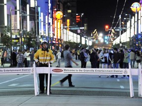 A traffic authority officer stands by the traffic barriers closing Granville Street in the entertainment district in this 2011 file photo. On July 8, 2017, two men were stabbed and two others arrested following a massive brawl downtown.