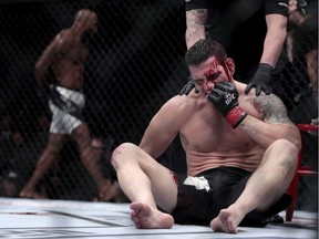 Chris Weidman sits in the octagon after being knocked out by Yoel Romero, left, during a middleweight mixed martial arts bout at UFC 205, Saturday, Nov. 12, 2016, at Madison Square Garden in New York.