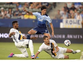 Los Angeles Galaxy defender Bradley Diallo (18) and defender Daniel Steres (5) defend against Vancouver Whitecaps midfielder Christian Bolanos (7) during the first half at StubHub Center.