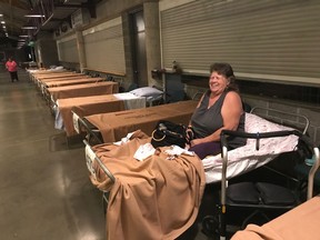 Betty-Lou Johnson of Williams Lake sits on an emergency cot Sunday in the concourse of the Sandman Centre in Kamloops.