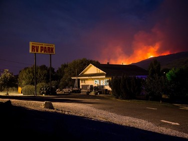 A wildfire burns on a mountain behind an RV park office in Cache Creek, B.C., in the early morning hours of Saturday July 8, 2017. More than 3,000 residents have been evacuated from their homes in central British Columbia.