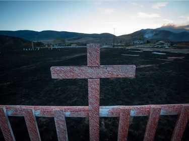 Fire retardant coats a cross at a cemetery on the Ashcroft First Nation where numerous homes were destroyed by wildfire, near Ashcroft, B.C., late Sunday July 9, 2017. THE CANADIAN PRESS/Darryl Dyck ORG XMIT: VCRD226
DARRYL DYCK,