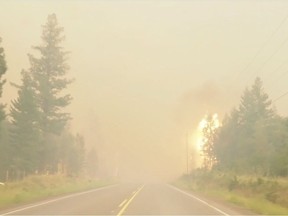 A wildfire burns by the side of the highway in British Columbia's West Chilcotin region in this handout photo taken from video. At first, the drive didn't seem too bad. Sally Aitken and her husband decided to leave their cabin in British Columbia's West Chilcotin region due to wildfires on Sunday. They were not ordered to evacuate, but had been without power for days and the only highway out had recently reopened. As they drove along Highway 20, they saw nothing overly dramatic: light smoke, burned trees. Then they suddenly they found themselves in the middle of an intense blaze, with flames leaping on either side of the road and smoke so dark they could barely see.