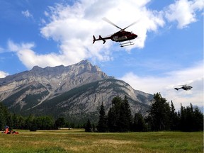 Conditions have eased around a wildfire sparked nearly two weeks ago in southeastern British Columbia, prompting the Regional District of Central Kootenay to rescind evacuation orders and alerts. Helicopters are seen leaving a fire base for the Verdant Creek wildfire in an undated Parks Canada handout image. The Verdant Creek wildfire has spread over about 25 to 30 square kilometres in Kootenay National Park and Mount Assiniboine Provincial Park in British Columbia on the Alberta boundary.