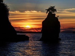 Silhouette of Siwash Rock at Sunset in Stanley Park.