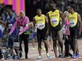 Jamaica's Usain Bolt, second right, walks with his teammates after he pulled up injured in the final of the Men's 4x100m relay during the World Athletics Championships in London Saturday, Aug. 12, 2017. (AP Photo/David J. Phillip)