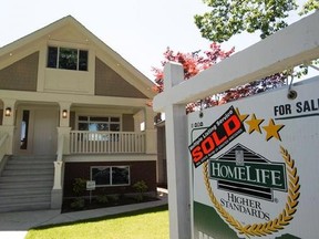 A sold sign is pictured outside a home in Vancouver, B.C., Tuesday, June 28, 2016. A coalition of environmental groups wants to see homes listed for resale in Canada to carry information about how much energy they use. THE CANADIAN PRESS/Jonathan Hayward