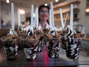 Tour guide Julie R. carries servings of soft serve ice cream to customers during a gourmet ice cream food tour in Vancouver, B.C., on Thursday August 17, 2017. THE CANADIAN PRESS/Darryl Dyck