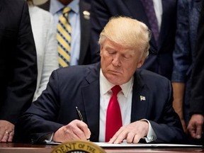 President Donald Trump signs the Education Federalism Executive Order during a federalism event with governors in the Roosevelt Room of the White House in Washington, Wednesday, April 26, 2017. (AP Photo/Andrew Harnik)