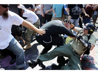 CHARLOTTESVILLE, VA - AUGUST 12:  White nationalists, neo-Nazis and members of the "alt-right" clash with counter-protesters as they enter Lee Park during the "Unite the Right" rally August 12, 2017 in Charlottesville, Virginia. After clashes with anti-fascist protesters and police the rally was declared an unlawful gathering and people were forced out of Lee Park, where a statue of Confederate General Robert E. Lee is slated to be removed.