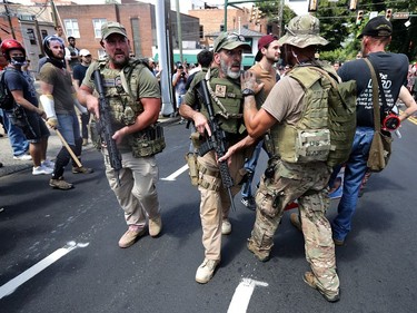 CHARLOTTESVILLE, VA - AUGUST 12:  White nationalists, neo-Nazis and members of the "alt-right" with body armor and combat weapons evacuate comrades who were pepper sprayed after the "Unite the Right" rally was declared a unlawful gathering by Virginia State Police August 12, 2017 in Charlottesville, Virginia. After clashes with anti-fascist protesters and police the rally was declared an unlawful gathering and people were forced out of Lee Park, where a statue of Confederate General Robert E. Lee is slated to be removed.