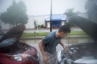 A man tries to jumpstart a disabled car in the aftermath of Hurricane Harvey August 27, 2017 in Houston, Texas.