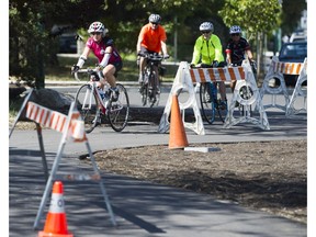 Cyclists ride along the almost completed Point Grey Seaside Greenway project on Friday, next to barricades dividing the bike lanes.