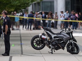 A police officer stands by a motorcycle that was righted after a female stunt driver working on the movie "Deadpool 2" died after a crash on set, in Vancouver, B.C., on Monday August 14, 2017.