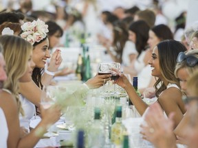 Simer Kaur (L) and Rubee Chane (R) toast at Le Diner en Blanc at Concord Pacific Place Vancouver, August 18, 2016.