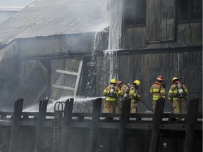 Richmond firefighters work  to put out the fire on a commercial dock in Steveston.