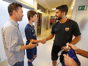 FC Barcelona player Luis Suarez shakes hands with Duncan Bates, the 14-year-old grandson of Ian Moore Wilson who was the 75 year-old Canadian victim of the terror attack in Barcelona, Spain. Bates is pictured with his father Rob Bates.