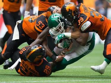 Saskatchewan Roughriders' Nic Demski, centre, is tackled by B.C. Lions' Steven Clarke (29), Jordan Herdman (53) and Chandler Fenner (39) during the second half of a CFL football game in Vancouver, B.C., on Saturday August 5, 2017.